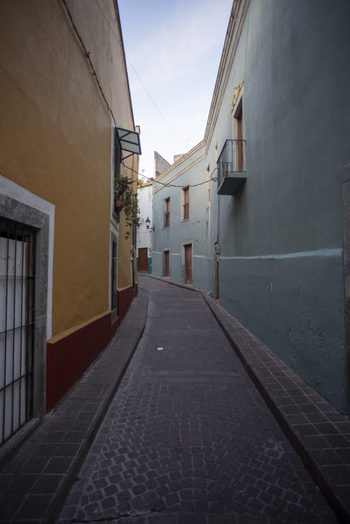 View of a narrow cobblestone street lined with colorful colonial buildings and balconies in Guanajuato Guanajuato Mexico. View of a narrow cobblestone street lined with colorful colonial buildings and balconies in Guanajuato Guanajuato Mexico.