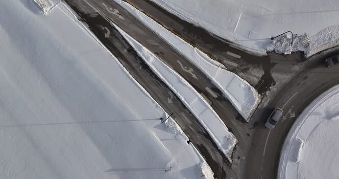 Aerial view of a snowy road intersection and car in Reading United States. Aerial view of a snowy road intersection and car in Reading United States.