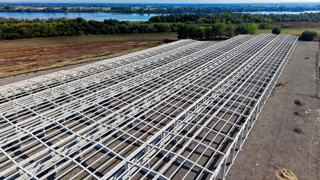 Aerial view of the large industrial hall structure with a steel frame skeleton situated near the river in Kovin Vojvodina Serbia. Aerial view of the large industrial hall structure with a steel frame skeleton situated near the river in Kovin Vojvodina Serbia.