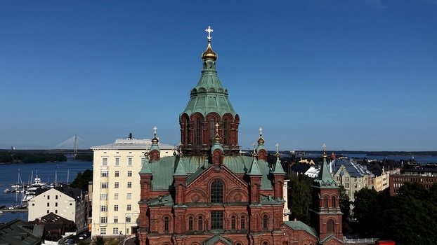 Aerial view of Uspenski Cathedral with its iconic red brick walls and green domes overlooking the harbor and cityscape in Helsinki Uusimaa Finland. Aerial view of Uspenski Cathedral with its iconic red brick walls and green domes overlooking the harbor and cityscape in Helsinki Uusimaa Finland.