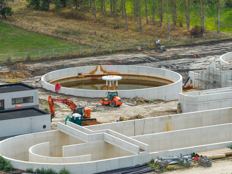 Vilvoorde Belgium 30 August 2026 Aerial view of the wastewater treatment plant under construction showing circular concrete tanks heavy machinery and surrounding green fields. Vilvoorde Belgium 30 August 2026 Aerial view of the wastewater treatment plant under construction showing circular concrete tanks heavy machinery and surrounding green fields.