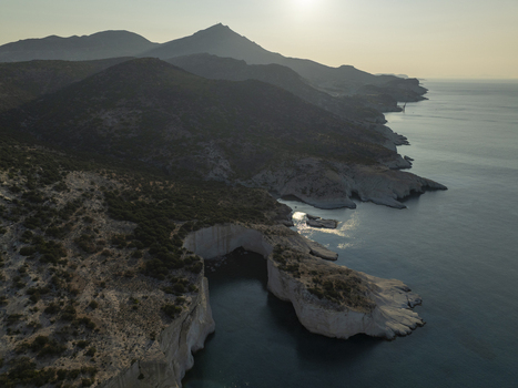 Aerial view of the white volcanic cliffs of Sarakiniko beach with turquoise waters and rugged coastline under the soft light of the golden hour in Milos Greece. Aerial view of the white volcanic cliffs of Sarakiniko beach with turquoise waters and rugged coastline under the soft light of the golden hour in Milos Greece.