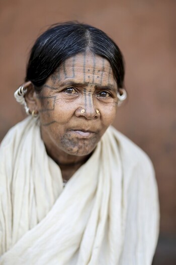 Odisha India 26 March 2026 View of an indigenous woman with traditional tattoos adorned in a cream colored shawl standing against a textured earthy toned backdrop. Odisha India 26 March 2026 View of an indigenous woman with traditional tattoos adorned in a cream colored shawl standing against a textured earthy toned backdrop.
