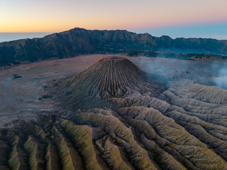 Aerial view of Mount Bromo volcano with its rugged crater and volcanic landscape at sunrise in the caldera of Bromo Tengger Semeru National Park Kecamatan Tosari Jawa Timur Indonesia. Aerial view of Mount Bromo volcano with its rugged crater and volcanic landscape at sunrise in the caldera of Bromo Tengger Semeru National Park Kecamatan Tosari Jawa Timur Indonesia.