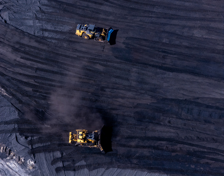 Aerial view of heavy equipment operating on a large coal pile at a power plant in West Olive Michigan United States. Aerial view of heavy equipment operating on a large coal pile at a power plant in West Olive Michigan United States.