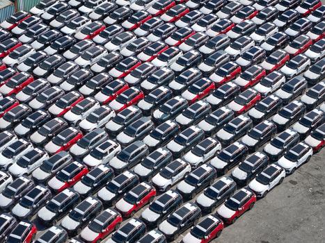 Aerial view of rows of new cars parked in a large logistics terminal in Vado Ligure Liguria Italy.