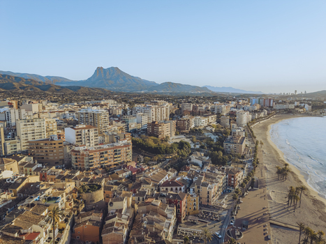 Aerial view of colorful coastal buildings and the sandy beach with mountains in the background La Vila Joiosa Valencian Community Spain. Aerial view of colorful coastal buildings and the sandy beach with mountains in the background La Vila Joiosa Valencian Community Spain.