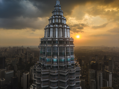 Kuala Lumpur Malaysia 11 March 2026 Aerial view of the Petronas Twin Towers at sunset with dramatic clouds and the urban skyline in the background.