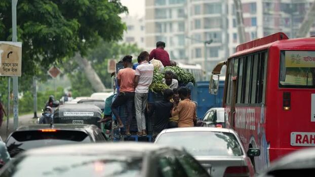 View of people on an overloaded truck in heavy traffic Bangladesh.