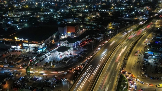Aerial view of the illuminated Atlantic Mall and busy highway with light trails from traffic at night in Ghana. Aerial view of the illuminated Atlantic Mall and busy highway with light trails from traffic at night in Ghana.
