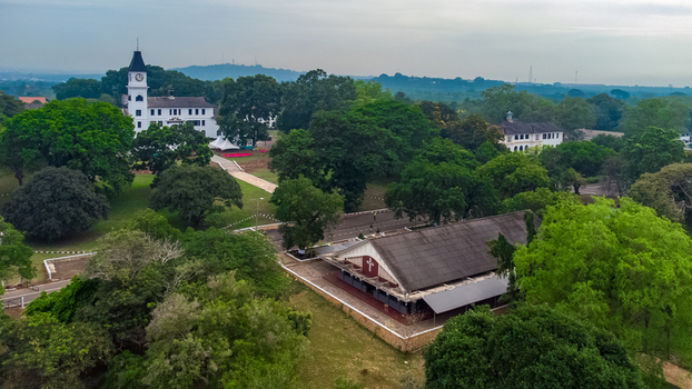 Aerial view of the historic Achimota School campus featuring its iconic clock tower building surrounded by lush green trees and pathways in Achimota Greater Accra Region Ghana. Aerial view of the historic Achimota School campus featuring its iconic clock tower building surrounded by lush green trees and pathways in Achimota Greater Accra Region Ghana.