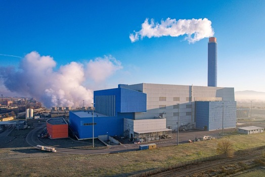 Aerial view of the Termovalorizzatore di Torino waste to energy plant featuring a tall chimney emitting white steam under a clear blue sky Torino Piemonte Italy. Aerial view of the Termovalorizzatore di Torino waste to energy plant featuring a tall chimney emitting white steam under a clear blue sky Torino Piemonte Italy.
