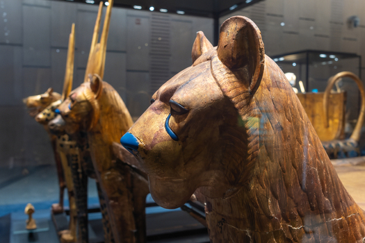 Giza Governorate Egypt 16 May 2026 View of The Grand Egyptian Museum featuring golden lion headed funerary beds and ancient artifacts displayed in glass cases. Giza Governorate Egypt 16 May 2026 View of The Grand Egyptian Museum featuring golden lion headed funerary beds and ancient artifacts displayed in glass cases.