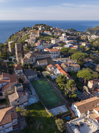 Aerial view of sun drenched terracotta rooftops cascade down the hillside towards the azure sea overlooked by the ancient tower in Ravello Campania Italy. Aerial view of sun drenched terracotta rooftops cascade down the hillside towards the azure sea overlooked by the ancient tower in Ravello Campania Italy.