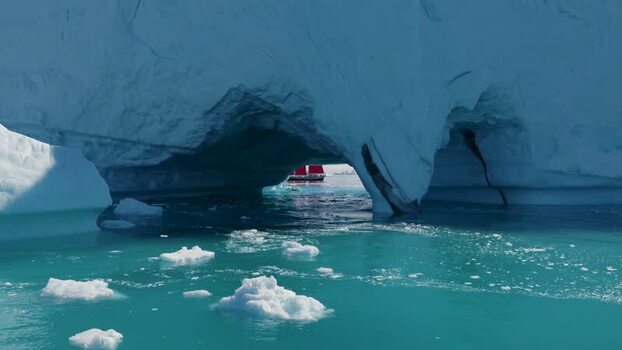 Aerial view of iceberg with red boat in Greenland. Aerial view of iceberg with red boat in Greenland.