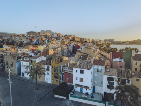Aerial view of the iconic colorful houses and palm trees along the waterfront under a clear sky in La Vila Joiosa Valencian Community Spain. Aerial view of the iconic colorful houses and palm trees along the waterfront under a clear sky in La Vila Joiosa Valencian Community Spain.