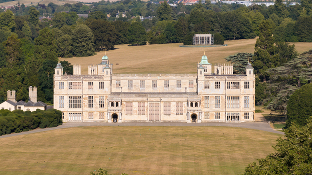 Aerial view of Audley End House a grand Jacobean mansion set within expansive lawns and surrounded by lush trees under a clear sky Audley End England United Kingdom. Aerial view of Audley End House a grand Jacobean mansion set within expansive lawns and surrounded by lush trees under a clear sky Audley End England United Kingdom.