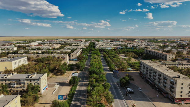 Aerial view of the residential area of Baikonur Cosmodrome with apartment buildings tree lined streets and roads under a clear blue sky in Karmakshy District Kyzylorda Region Kazakhstan.