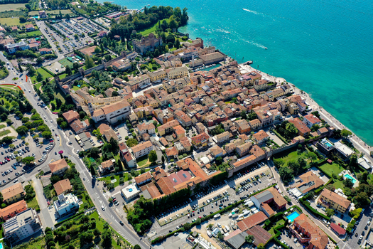 Aerial view of the historic town of Lazise with its medieval walls and red tiled rooftops along the shores of Lake Garda Provincia di Verona Veneto Italy.