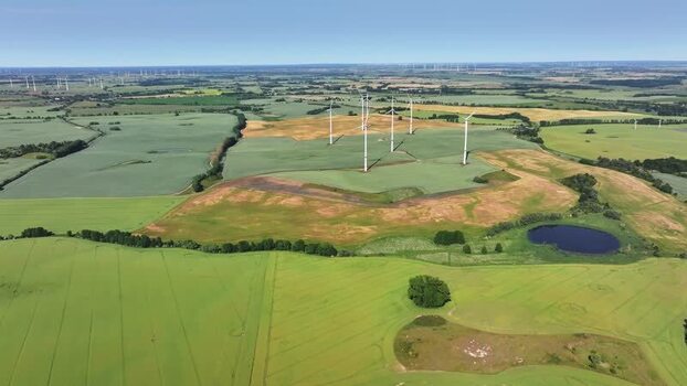 Aerial view of wind turbines in green fields Germany.