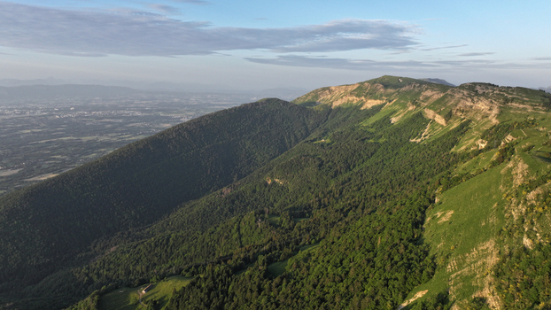 Aerial view of Col de la Faucille featuring lush green mountain slopes rocky ridges and expansive valley views in Gex Auvergne Rhone Alpes France.