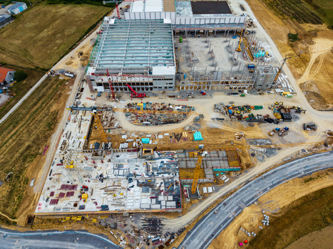 Aerial view of the Neuenstein Techno Zone construction site featuring large industrial structures cranes and concrete foundations surrounded by rural fields in Neuenstein Baden Wurttemberg Germany. Aerial view of the Neuenstein Techno Zone construction site featuring large industrial structures cranes and concrete foundations surrounded by rural fields in Neuenstein Baden Wurttemberg Germany.