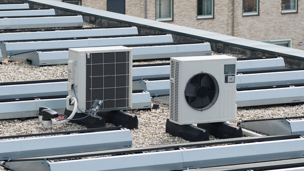 Aerial view of modern air conditioning units and heat pumps installed on a gravel rooftop in Almere Flevoland Netherlands. Aerial view of modern air conditioning units and heat pumps installed on a gravel rooftop in Almere Flevoland Netherlands.