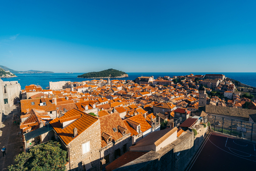 View of Dubrovnik Old Town with its iconic red tiled rooftops historic stone buildings and the Adriatic Sea with Lokrum Island in Dubrovnik Dubrovnik Neretva County Croatia. View of Dubrovnik Old Town with its iconic red tiled rooftops historic stone buildings and the Adriatic Sea with Lokrum Island in Dubrovnik Dubrovnik Neretva County Croatia.