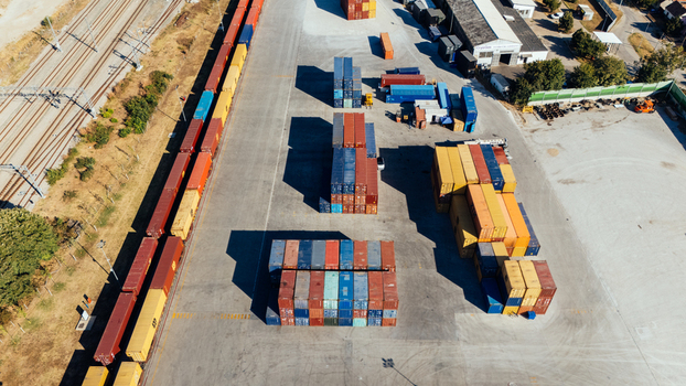 Indjija Serbia 24 August 2026 Aerial view of a busy freight terminal with rows of colorful shipping containers and freight train cars parked on tracks in an industrial area.