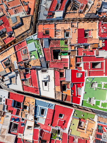 Aerial view of colorful flat rooftops with red green and white surfaces skylights and ventilation units in a dense urban area in Andalusia Spain. Aerial view of colorful flat rooftops with red green and white surfaces skylights and ventilation units in a dense urban area in Andalusia Spain.