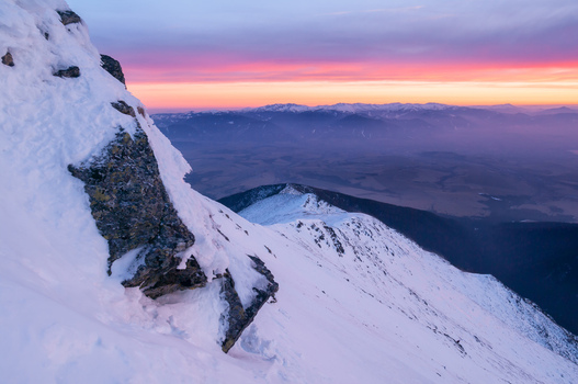 View of the snow covered Baranec peak in the Western Tatras during a vibrant sunset with purple and orange sky in Jamnik Zilina Region Slovakia. View of the snow covered Baranec peak in the Western Tatras during a vibrant sunset with purple and orange sky in Jamnik Zilina Region Slovakia.