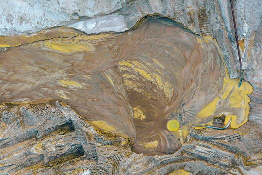 Aerial view of gravel and sand mine showing abstract sediment patterns and industrial textures in Poland.