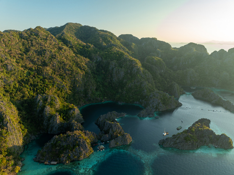 Aerial view of Twin Lagoon featuring dramatic limestone cliffs turquoise waters and boats Coron Mimaropa Philippines. Aerial view of Twin Lagoon featuring dramatic limestone cliffs turquoise waters and boats Coron Mimaropa Philippines.