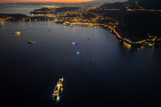 Aerial view of the illuminated coastline and boats on the dark sea at twilight in Eze Provence Alpes Cote d Azur France. Aerial view of the illuminated coastline and boats on the dark sea at twilight in Eze Provence Alpes Cote d Azur France.