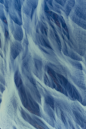 Aerial view of intricate patterns of blue braided glacial rivers flowing through volcanic sediment Hofn Sveitarfelagid Hornafjordur Iceland.