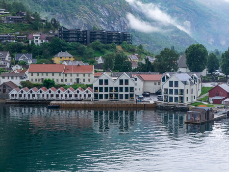 Flam Vestland Norway 19 June 2026 Aerial view of the village of Flam nestled along the Aurlandsfjord featuring traditional wooden houses a modern waterfront hotel and lush green mountains under a cloudy sky. Flam Vestland Norway 19 June 2026 Aerial view of the village of Flam nestled along the Aurlandsfjord featuring traditional wooden houses a modern waterfront hotel and lush green mountains under a cloudy sky.