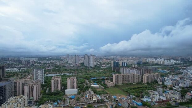 Aerial view of Gurugram skyscrapers and green fields India.