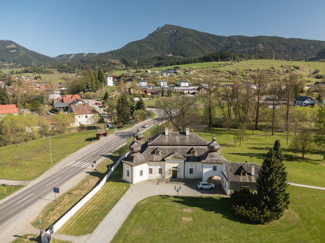 Aerial view of the historic Kastiel Kubinyi manor house with onion domes and the prominent Velky Choc mountain peak in the background Vysny Kubin Zilinsky kraj Slovakia.