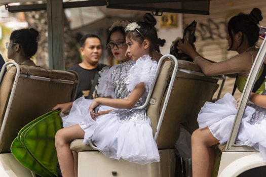 Hanoi Vietnam 11 November 2025 View of young girls in white performance dresses sitting in a tourist vehicle in Hanoi.