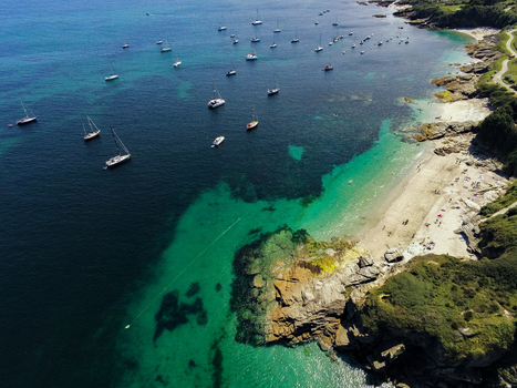 Aerial view of Ile de Groix featuring turquoise waters a sandy beach and numerous sailboats anchored in the bay Groix Bretagne France. Aerial view of Ile de Groix featuring turquoise waters a sandy beach and numerous sailboats anchored in the bay Groix Bretagne France.