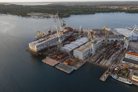 Aerial view of Uljanik Shipyard with large industrial cranes and ships under construction along the waterfront in Pula Istarska zupanija Croatia. Aerial view of Uljanik Shipyard with large industrial cranes and ships under construction along the waterfront in Pula Istarska zupanija Croatia.