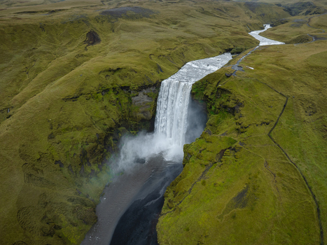 Aerial view of Skógafoss waterfall cascading dramatically through verdant hills a powerful display of nature s artistry Skógafoss Rangárþing eystra Iceland. Aerial view of Skógafoss waterfall cascading dramatically through verdant hills a powerful display of nature s artistry Skógafoss Rangárþing eystra Iceland.