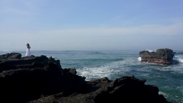 Aerial view of a woman on the rocky coast of Bali Indonesia. Aerial view of a woman on the rocky coast of Bali Indonesia.