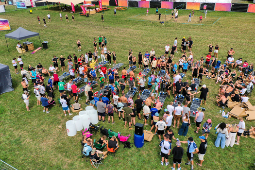 Herzogenaurach Germany 26 July 2025 Aerial view of the Open Beatz Festival with a large crowd of people gathered around gaming tables on a grassy field.