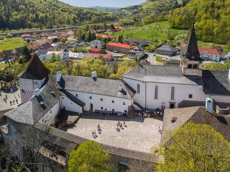 Aerial view of Orava Castle showing the inner courtyard with people historic white stone buildings and a tall tower overlooking the town in Dolny Kubin Zilinsky kraj Slovakia. Aerial view of Orava Castle showing the inner courtyard with people historic white stone buildings and a tall tower overlooking the town in Dolny Kubin Zilinsky kraj Slovakia.