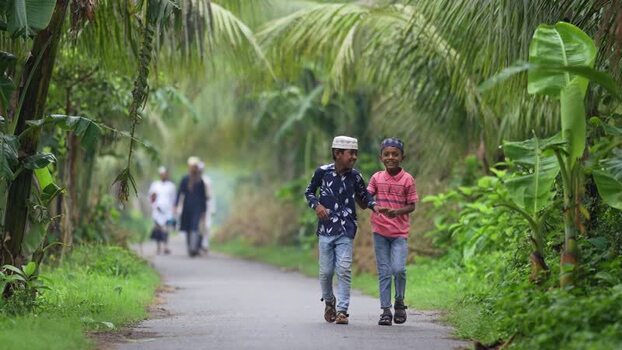 View of two boys walking along a lush tropical path Bangladesh. View of two boys walking along a lush tropical path Bangladesh.