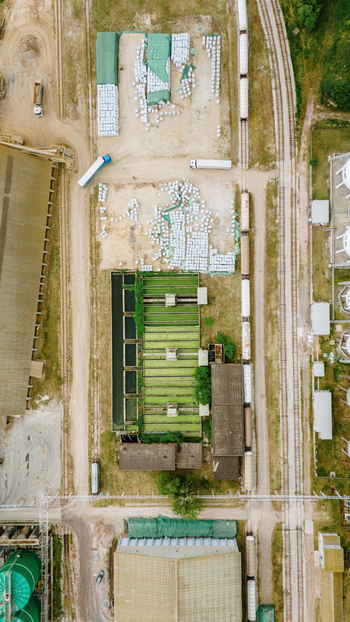 Aerial view of industrial facility with railway tracks freight cars storage areas and green processing pools under bright daylight in Sabac Vojvodina Serbia. Aerial view of industrial facility with railway tracks freight cars storage areas and green processing pools under bright daylight in Sabac Vojvodina Serbia.