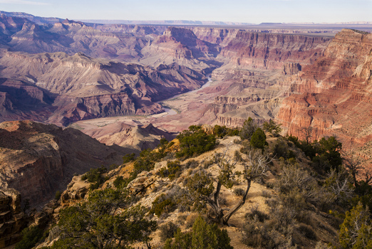 View of the Grand Canyon with its vast red rock formations deep gorges and the Colorado River winding through the landscape in Coconino County Arizona United States. View of the Grand Canyon with its vast red rock formations deep gorges and the Colorado River winding through the landscape in Coconino County Arizona United States.