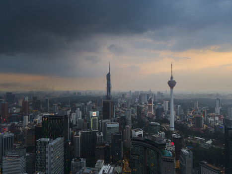 Kuala Lumpur Malaysia 11 March 2026 Aerial view of the city skyline featuring Merdeka 118 and KL Tower under a dramatic sunset sky with dark storm clouds.