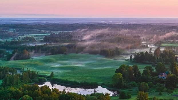 Aerial view of lush green fields and mist in Latvia. Aerial view of lush green fields and mist in Latvia.